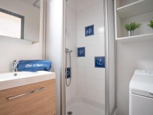 レ・ズィサンブルにあるApartment Le Domaine de la Gaillarde-5 by Interhomeのバスルーム(青と白のタイル張りのシャワー付)