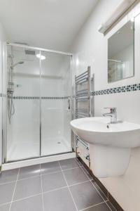 a white bathroom with a shower and a sink at Holiday Home Carnevas by Interhome in Saint Merryn