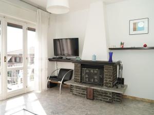 een woonkamer met een open haard en een tv bij Apartment Il Gallo Nero by Interhome in Brezzo