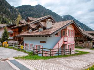 a house in a village with mountains in the background at Apartment Cesa Pra da Molin-3 by Interhome in Campitello