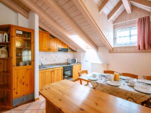 a kitchen with a wooden table and a dining room at Apartment Cesa Pra da Molin-4 by Interhome in Campitello