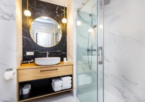 łazienka z prysznicem, umywalką i lustrem w obiekcie Bentis Luxury Apartments w Krakowie