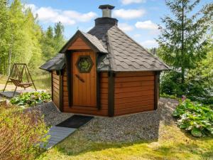 a small wooden dog house with a roof at Holiday Home 7152 by Interhome in Kaartilankoski