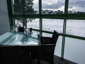 a table with wine glasses and a view of the snow at Apartment Flieder - F 96 by Interhome in Dittishausen