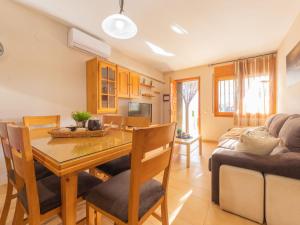 a dining room and living room with a table and a couch at Holiday Home Juan by Interhome in Riumar