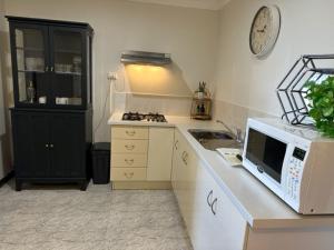 uma cozinha com um micro-ondas e um balcão com um lavatório em Comfort Inn Getaway em Perth