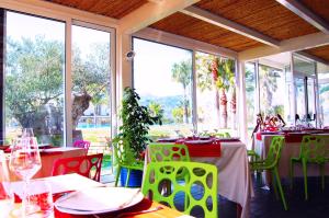 una sala da pranzo con tavoli, sedie e finestre di Kalos Relais a Catanzaro