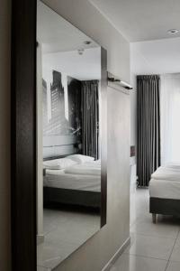 a mirror reflection of a bedroom with two beds at Super Stay Hotel, Oslo in Oslo