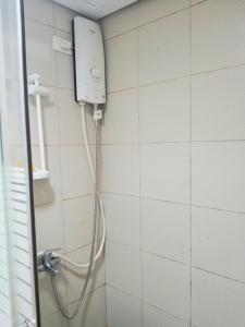 a shower in a bathroom with a hose on a wall at Family Group Affordable Staycation in tagaytay in Tagaytay