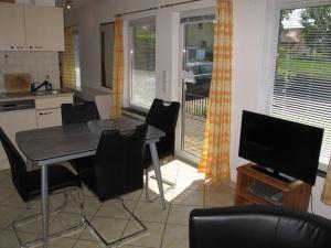 cocina con mesa y sillas y TV en Holiday Home Villa Meike - Insel Poel by Interhome en Kaltenhof