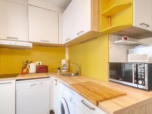 フレジュスにあるStudio L'Open-16 by Interhomeの黄色の壁と白いキャビネット付きのキッチン