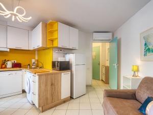 una cocina con electrodomésticos blancos y un sofá en una habitación en Studio L'Open-16 by Interhome, en Fréjus