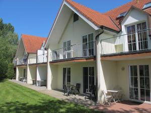 a house with a balcony and a table and chairs at Apartment Gollwitzer Park - Insel Poel-8 by Interhome in Gollwitz