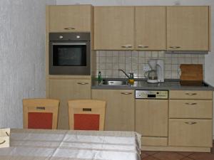 a kitchen with wooden cabinets and a sink at Apartment Gollwitzer Park - Insel Poel-1 by Interhome in Gollwitz