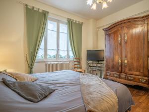 a bedroom with a large bed and a large wooden cabinet at Holiday Home Ker Maria by Interhome in Saint Malo