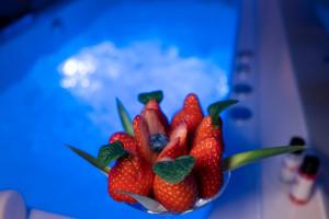 un tazón de fresas sentado en una mesa azul en Motel Emoções, en Nogueira da Regedoura