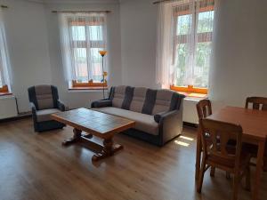 uma sala de estar com um sofá, uma mesa e cadeiras em Apartment Krátká by Interhome em Broumov