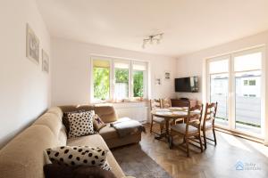 uma sala de estar com um sofá e uma mesa em Uroda Morza by 3City Rentals em Gdynia