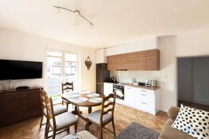 uma cozinha e sala de estar com mesa e cadeiras em Uroda Morza by 3City Rentals em Gdynia