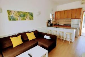 uma sala de estar com um sofá castanho e uma cozinha em Precioso Bungalow 1 em Playa del Inglés