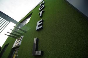 zielony budynek z zegarem na boku w obiekcie HIDE PARK HOTEL w mieście Bokhoniki