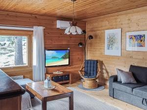 een woonkamer met een bank en een tv bij Holiday Home Riekkotupa by Interhome in Enontekiö