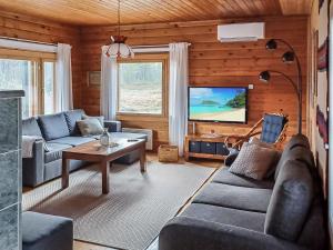 a living room with a couch and a tv at Holiday Home Riekkotupa by Interhome in Enontekiö
