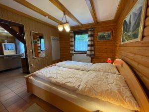 1 dormitorio con 1 cama grande en una habitación de madera en Apartment Am Hohen Bogen-50 by Interhome, en Arrach