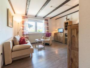 a living room with a couch and chairs and a tv at Apartment Am Hohen Bogen-26 by Interhome in Arrach