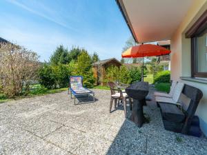 a patio with a table and chairs and an umbrella at Apartment Am Hohen Bogen-26 by Interhome in Arrach