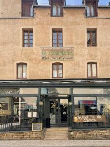 un edificio con una tienda delante de él en La Citadelle, en La Canourgue