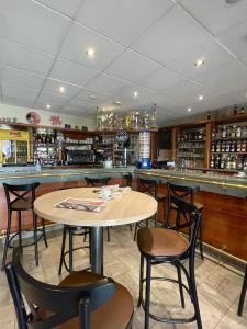 un restaurante con mesa y sillas y un bar en La Citadelle, en La Canourgue