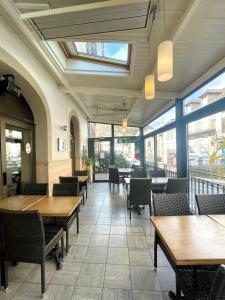 a restaurant with wooden tables and chairs and windows at La Citadelle in La Canourgue