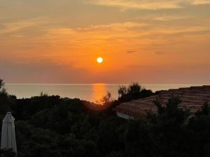 una puesta de sol sobre el océano con el sol en el cielo en Holiday Home Turriga by Interhome, en Aglientu