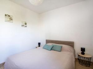 1 dormitorio con 1 cama blanca y 2 almohadas azules en Apartment Les Voiliers by Interhome, en Saint-Laurent-du-Var