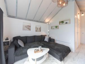 a living room with a couch and a table at Apartment La Bella Vita parking and shared pool by Interhome in De Haan