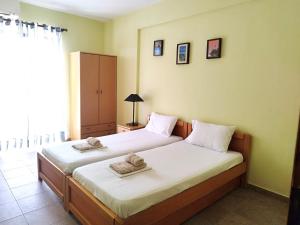 1 dormitorio con 2 camas y toallas. en Central Apartments, en Paralia Dionisiou