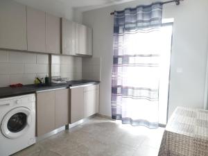 a kitchen with a washing machine and a window at Central Apartments in Paralia Dionysiou
