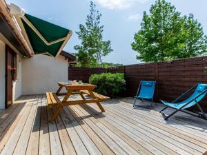 a wooden deck with a picnic table and two chairs at Holiday Home Paradise Océan-13 by Interhome in Capbreton