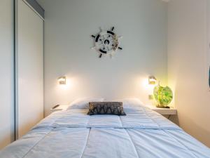 a bedroom with a large bed with a clock on the wall at Holiday Home Paradise Océan-13 by Interhome in Capbreton