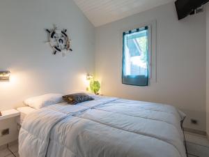 a bedroom with a bed with a clock on the wall at Holiday Home Paradise Océan-13 by Interhome in Capbreton +23 photos