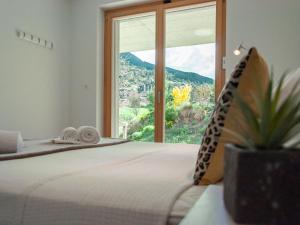 a bedroom with a bed and a large window at Chalet Les Penguins by Interhome in Nendaz