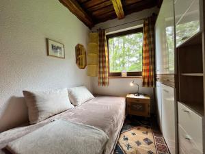 ein kleines Schlafzimmer mit einem Bett und einem Fenster in der Unterkunft Chalet Bodental 28 by Interhome in Bodental