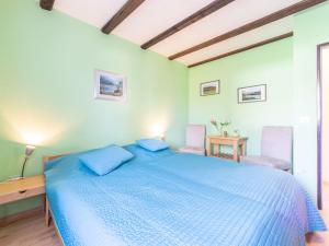 a bedroom with a blue bed and two chairs at Apartment Am Hohen Bogen-58 by Interhome in Kummersdorf