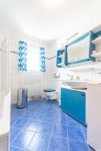 a blue and white bathroom with a toilet and a sink at Apartment Am Hohen Bogen-58 by Interhome in Kummersdorf