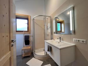 a white bathroom with a shower and a sink at Chalet Stressless by Interhome in Presseggen