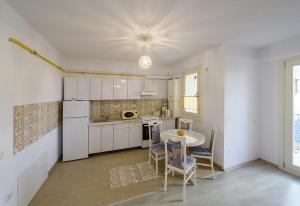 eine Küche mit weißen Schränken und einem Tisch und Stühlen in der Unterkunft Apartament Laur in Gura Humorului