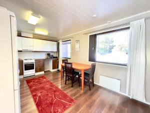 a kitchen with a table and chairs and a window at Apartment Kalliokuja in Pyhäjoki