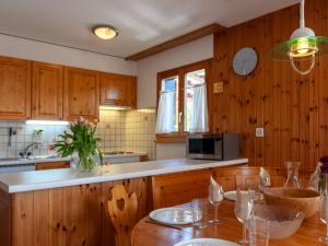 a kitchen with wooden cabinets and a wooden table at Apartment Les Crêtes 1-4 by Interhome in Veysonnaz