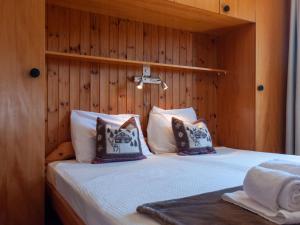 a bedroom with a bed with a wooden wall at Apartment Les Crêtes 1-4 by Interhome in Veysonnaz